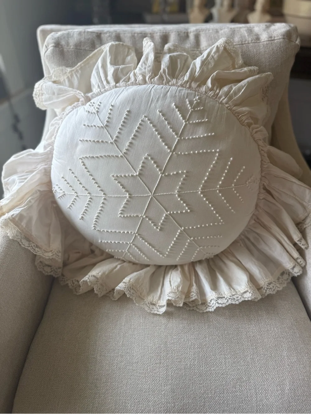 Handmade white candlewicking starburst pillow with ruffled lace trim.